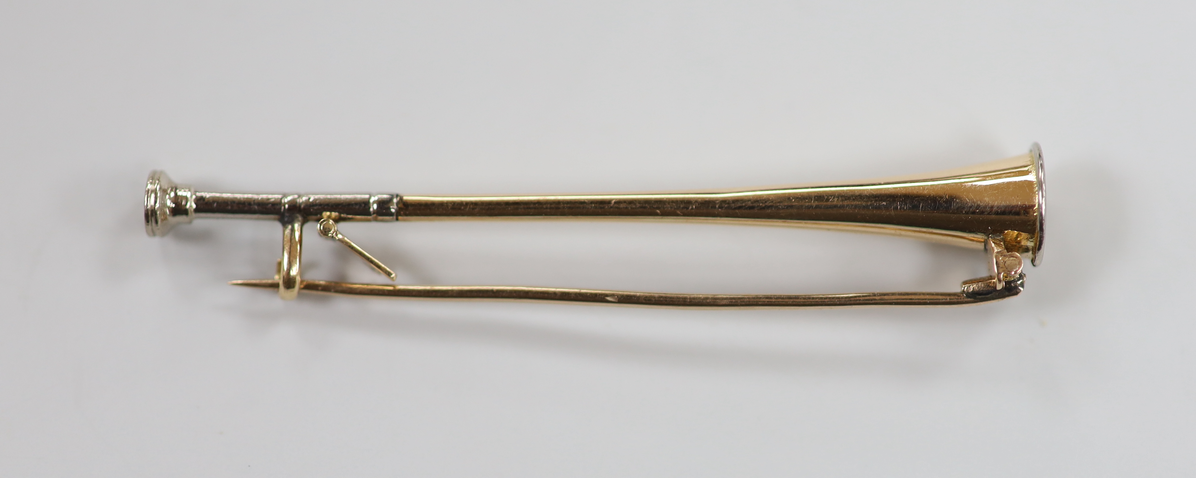 An early 20th century yellow and white metal hunting horn brooch, 56mm, 3.7 grams.